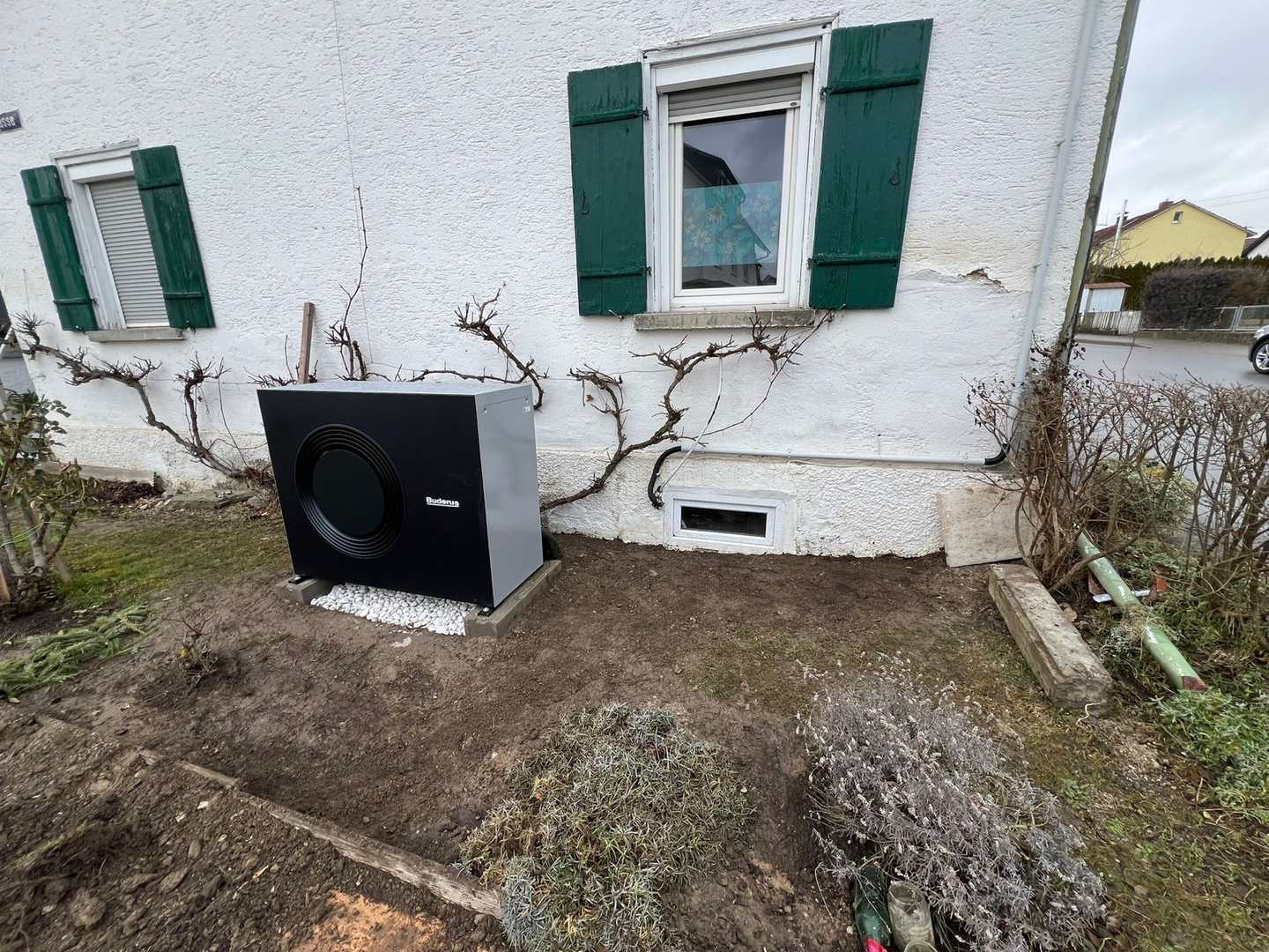 Weiße Wärmepumpen-Außeneinheit unter dem Fenster