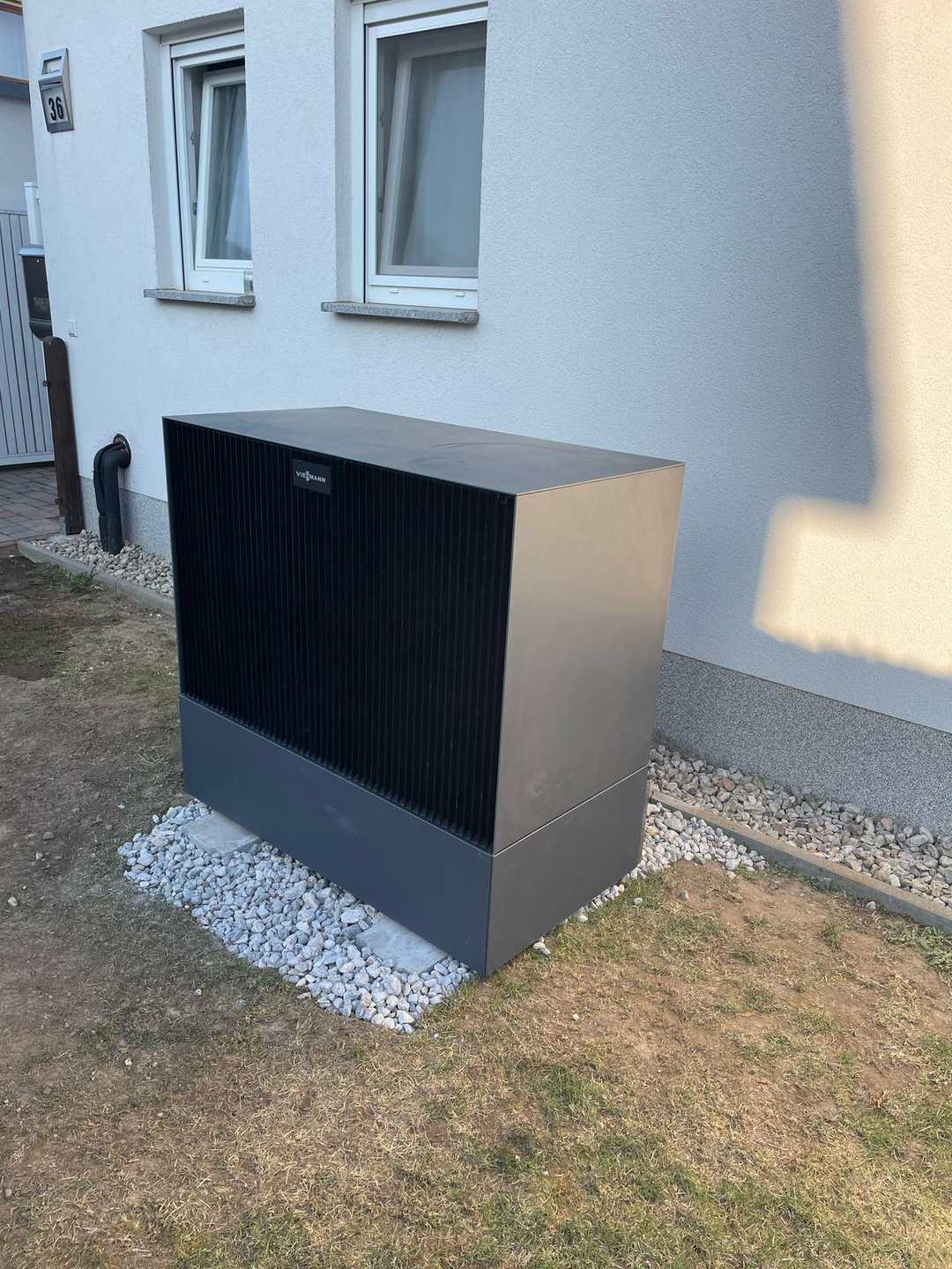 Viessmann-Außeneinheit auf Kiesbett neben dem Haus