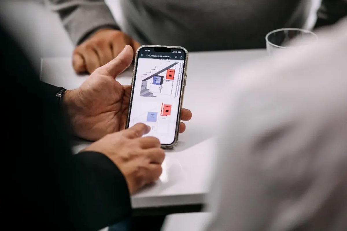 Berater zeigt eine Anlagenplanung auf dem Smartphone